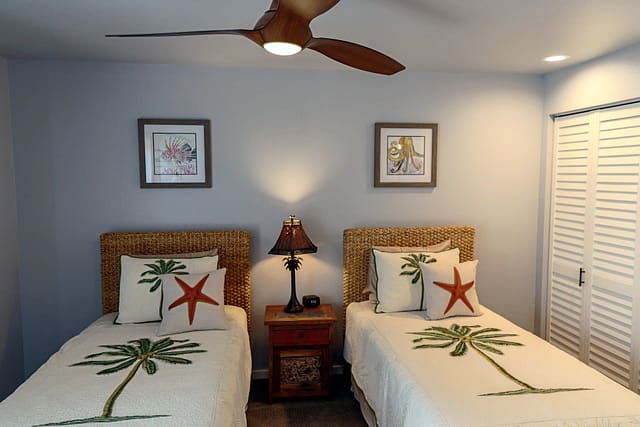 Low height ceiling fan with 2 twin beds and seagrass headboards.