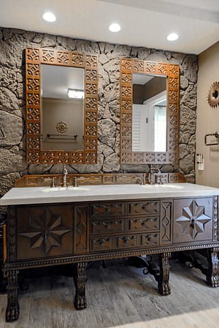 Carved wood, double bath vanity with carved wood framed mirrors above each sink.