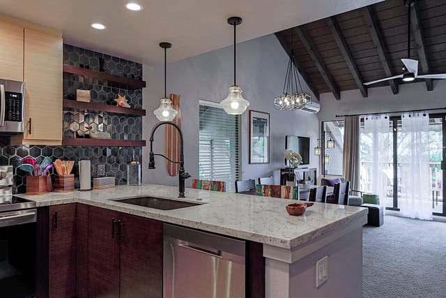 U-shaped kitchen with stainless steel appliances and 2 bar height stools.